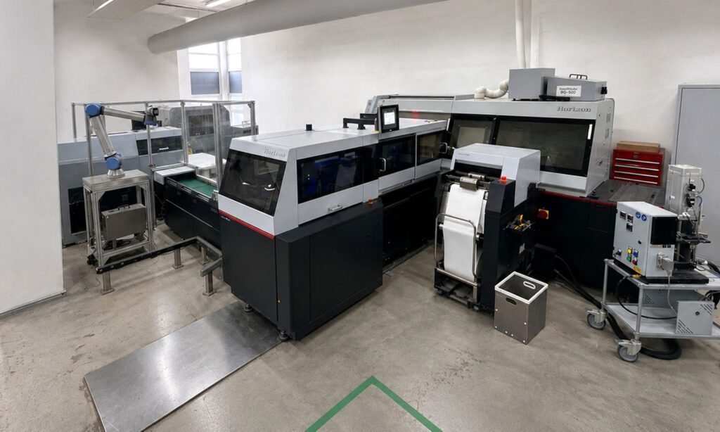 Ideal für die vollautomatische, variable Buchproduktion und personalisierte Produkte: Horizon Smart Binding System bestehend aus iCE Binder BQ-500 mit Gazezuführung GF-500, Vorsatzanleger ESF-1000 und Dreimesser-Vollautomat HT-1000V.